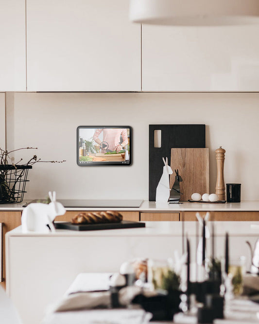Mounted iPad used as a smart home control panel on a wall in a modern kitchen